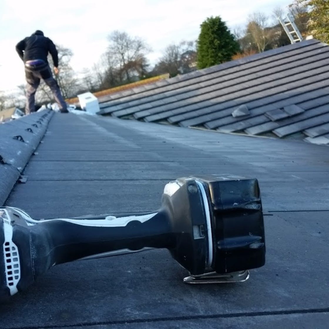 From below of high concrete building with metal constructions on roof against clear sky